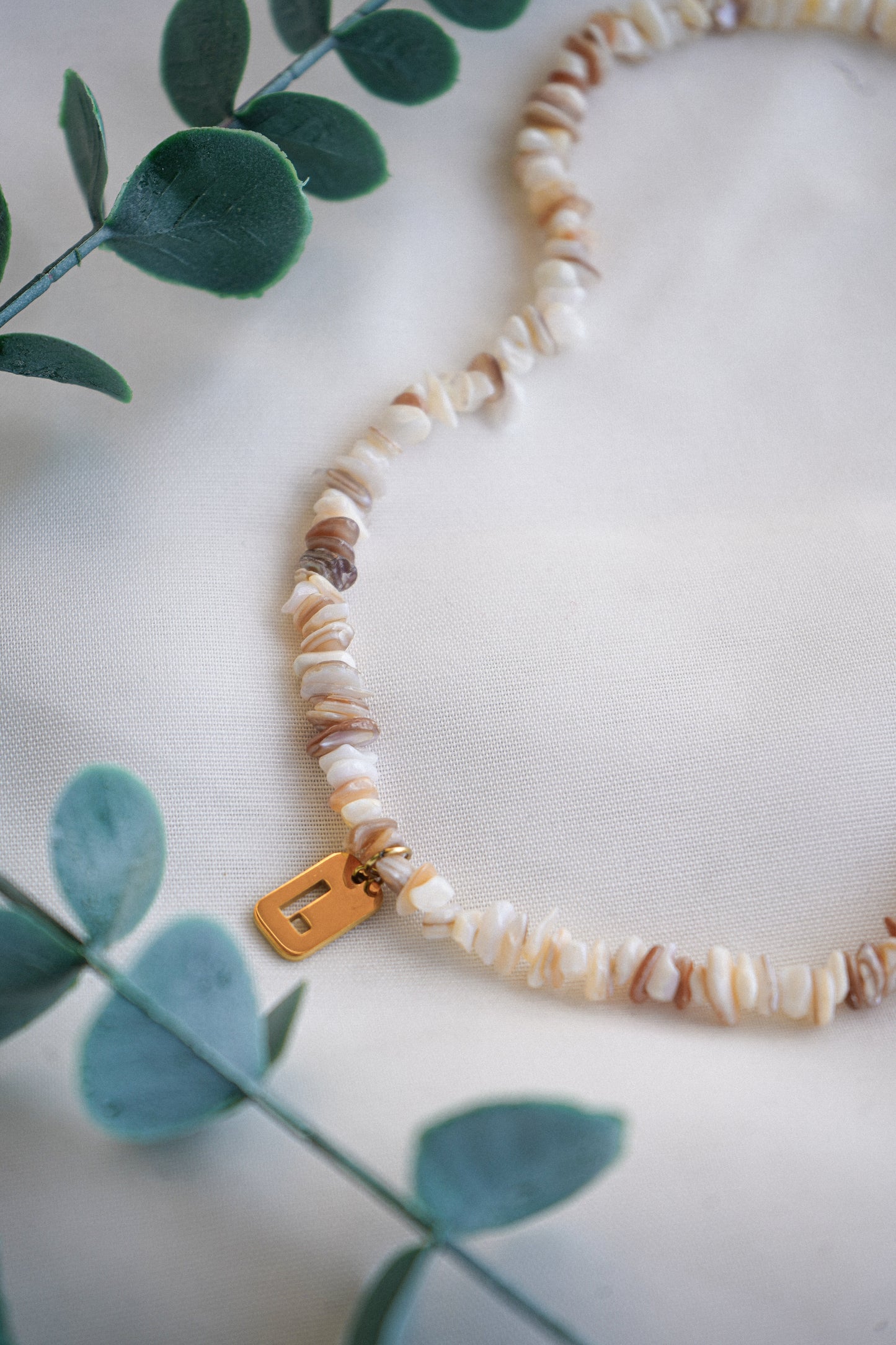 Colar de pedras e conchas com inicial